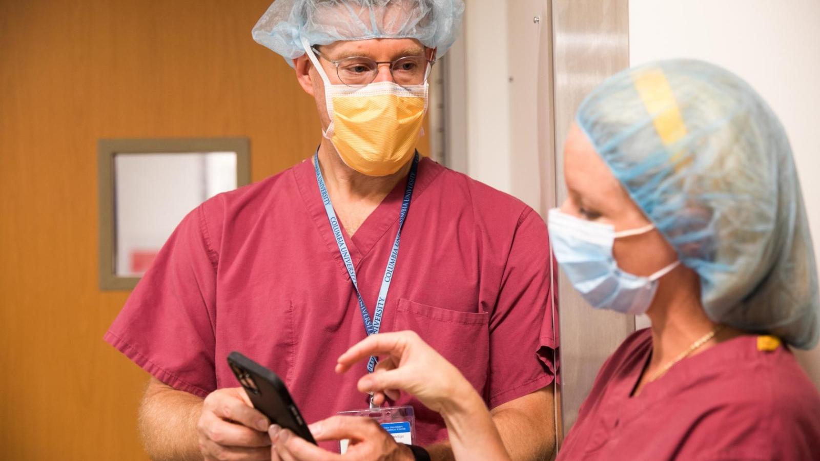 Doctors talking while looking at a phone