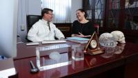 Doctor and patient sitting at a desk and talking to each other